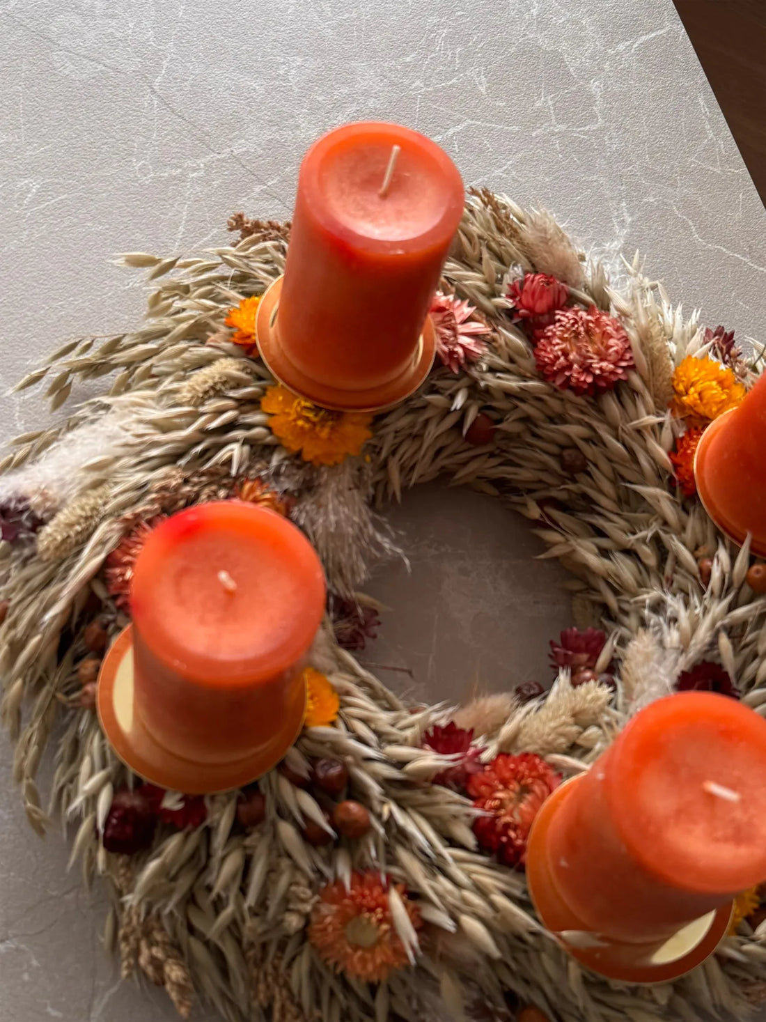 Ganzjährig einsetzbarer Trockenblumen Kranz mit orangefarbenen und roten Kerzen für Adventszeit