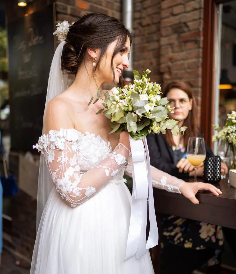 Huebsche Braut mit Blumen Accessoires, Brautstrauss und Haarkamm strahlend
