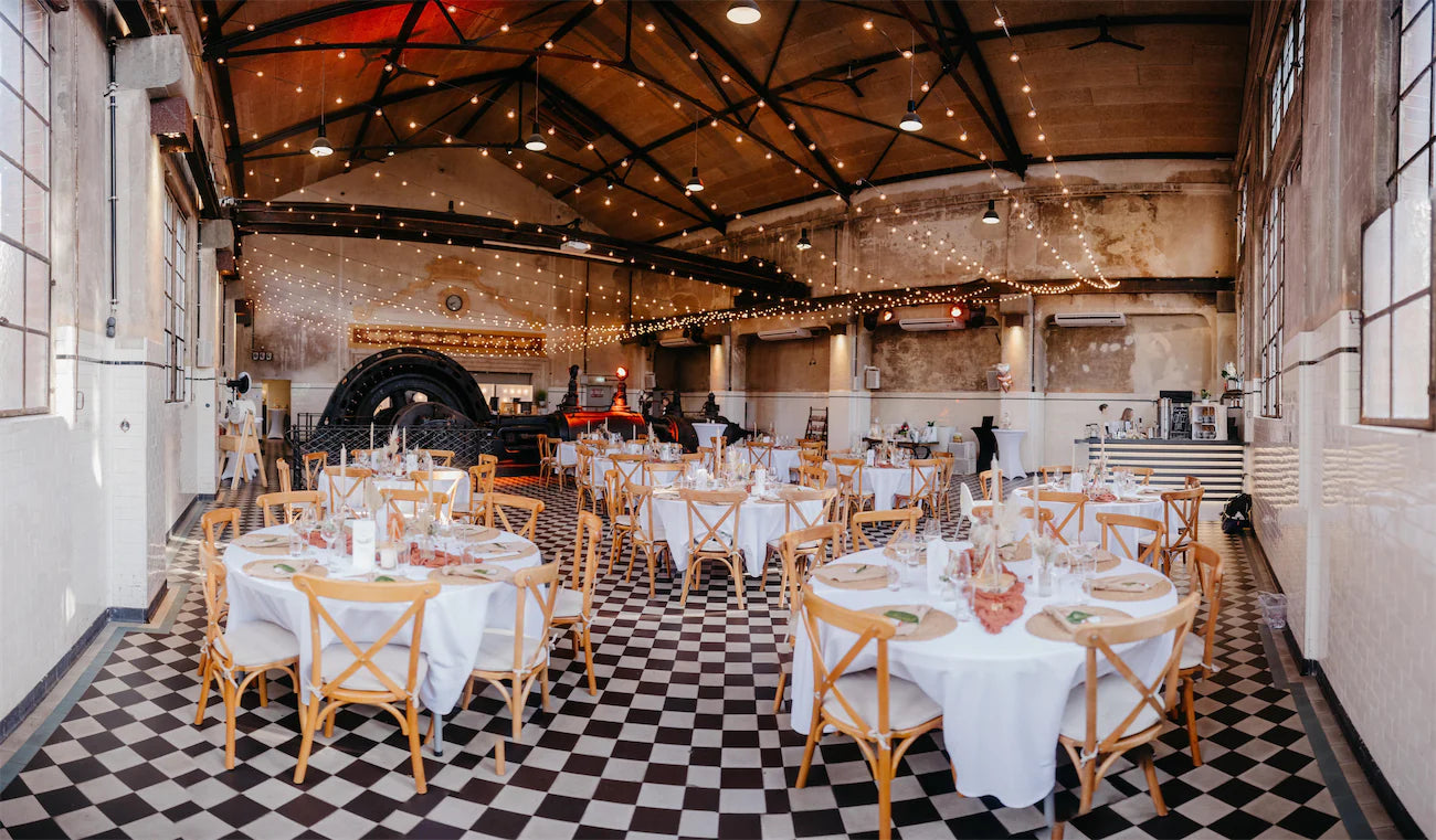 Hochzeitslocation stilvoll mit Lichterketten in alter Industriehalle und Hochzeitsdeko