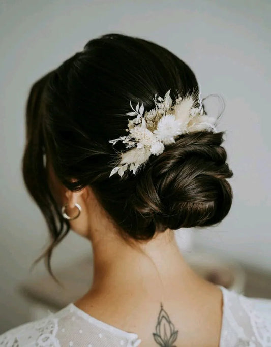 Frau trägt in der Brautfrisur einen Blumen Haarkamm mit hellen Blüten