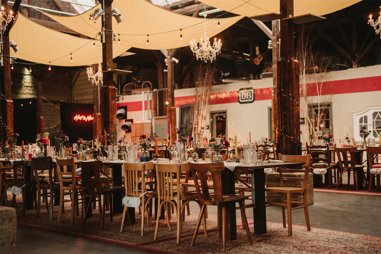 Auffaellige Dekoration für Eventlocation mit bunten Blumen und Kerzen