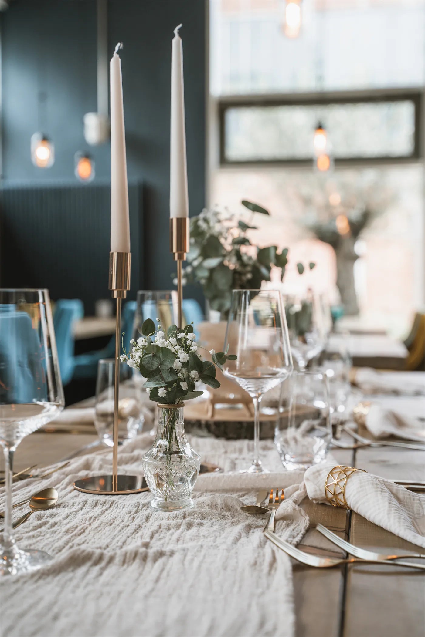 Tischdeko mit Eukalyptus, goldenem Besteck und Holz als gut kombinierbarer Evergreen bei Hochzeiten und Events